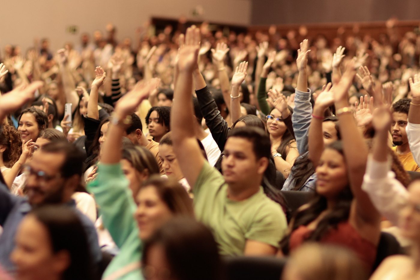 Plateia com as mãos levantadas durante evento do UniDoctum